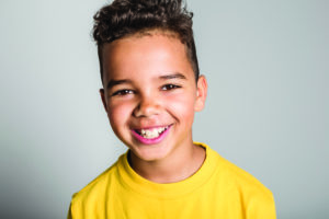 little boy smiling with yellow shirt