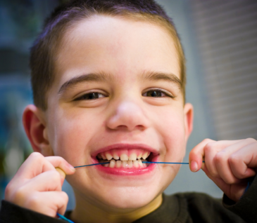 child flossing teeth